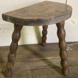 Half-moon tripod stool.
