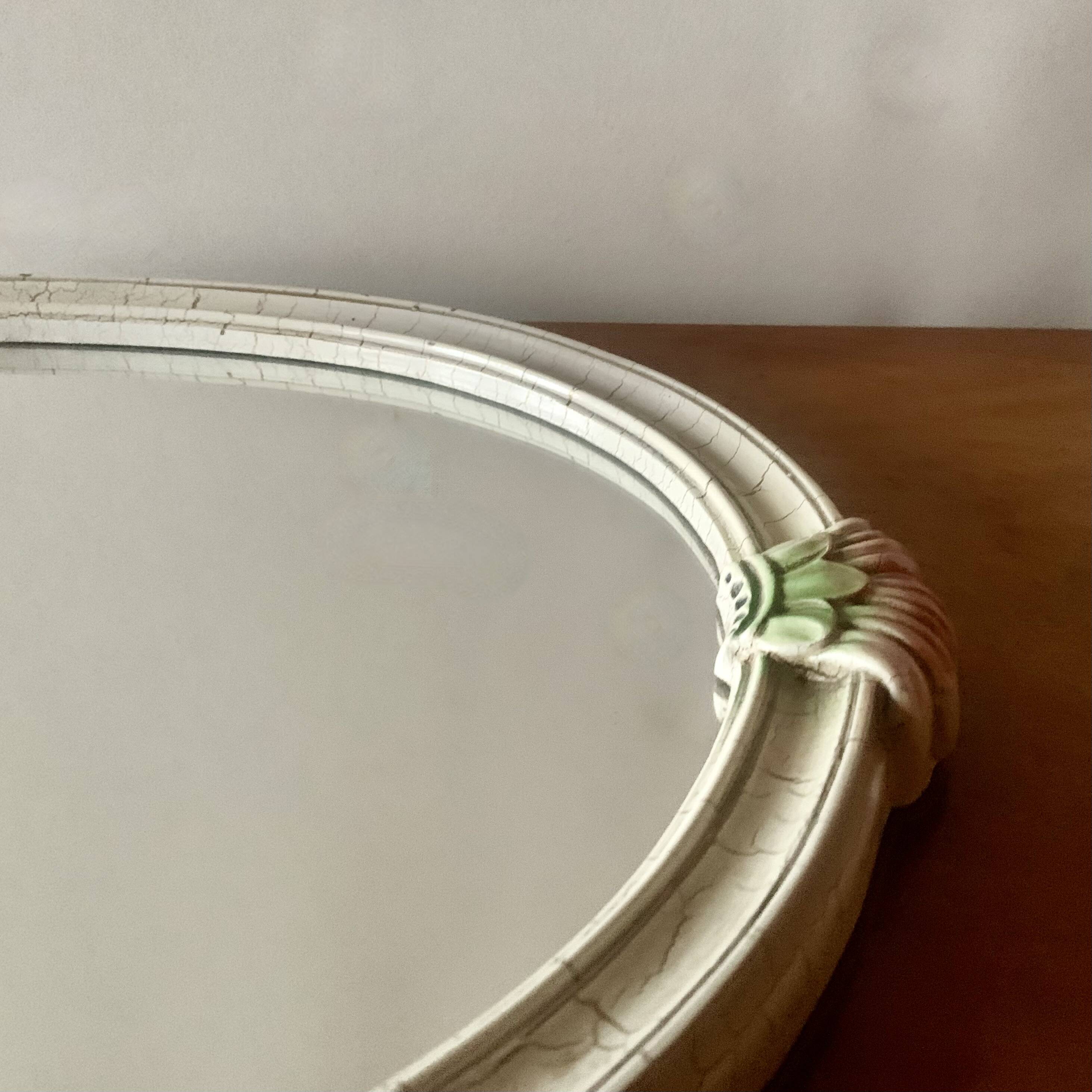 Vintage oval mirror in carved wood in pastel tones