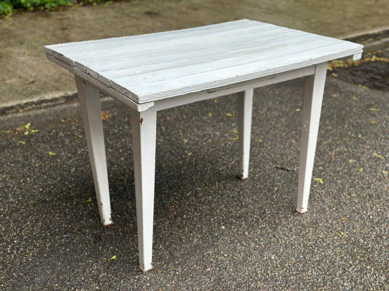 Vintage white wooden kitchen table with drawer from the 19th century.