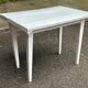Vintage white wooden kitchen table with drawer from the 19th century.