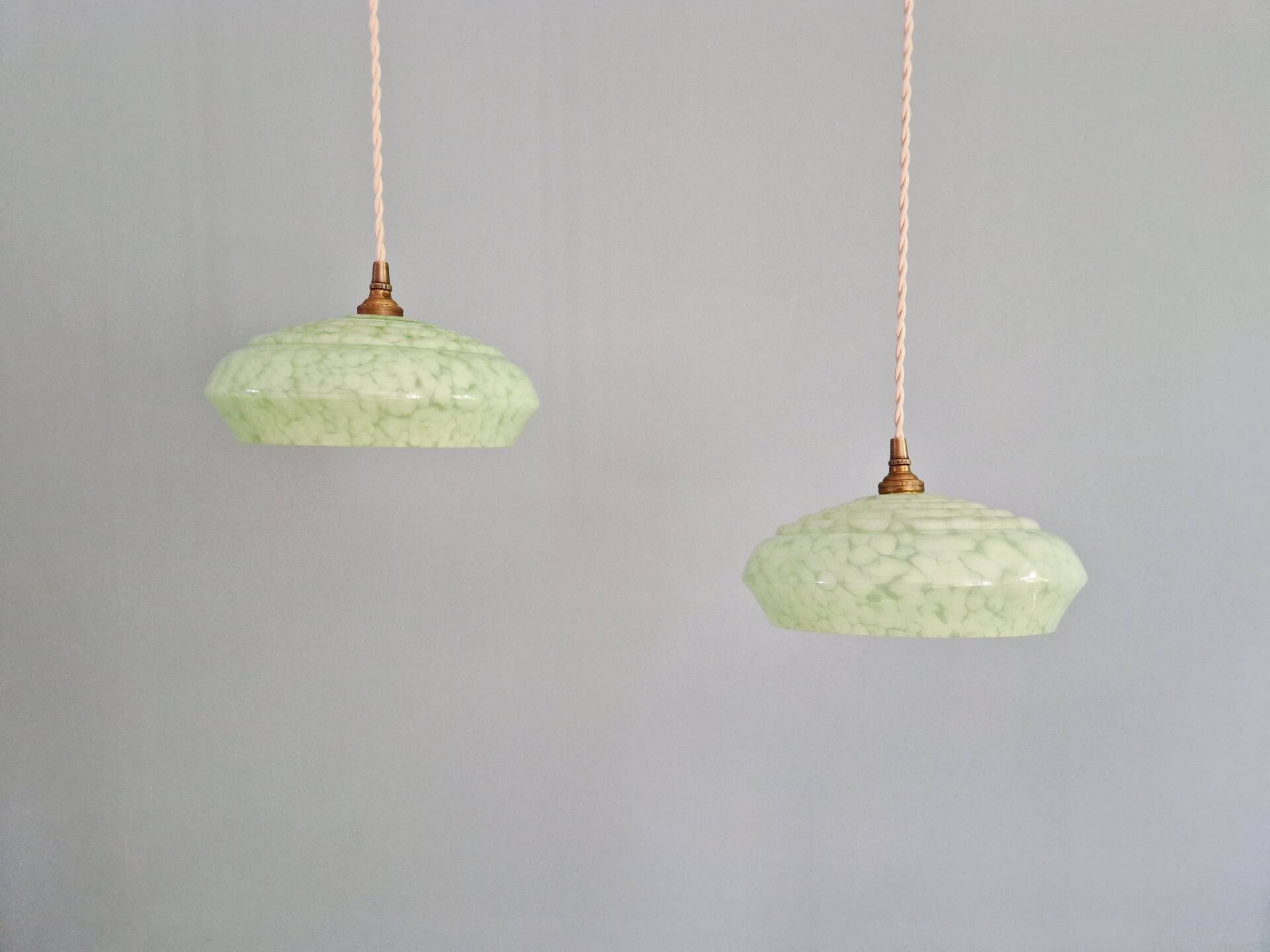 Pair of Art Deco light fixtures in light green speckled glass, 1930s.