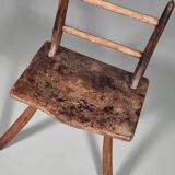 Rustic Wabi-Sabi style accent chair in dark curved hardwood, 1900s.