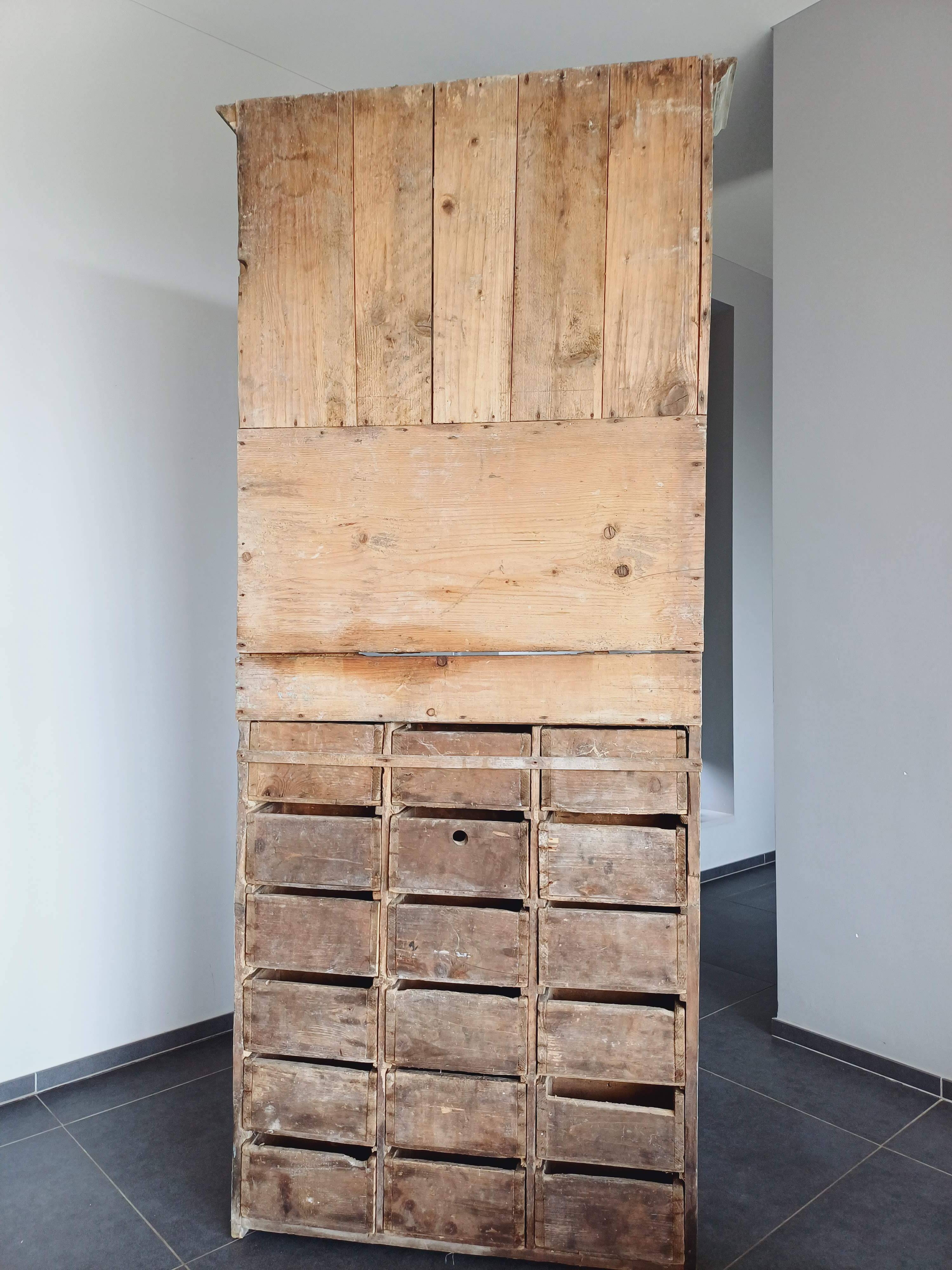 Craft cabinet with drawers with a very old tobacco advertisement in the background