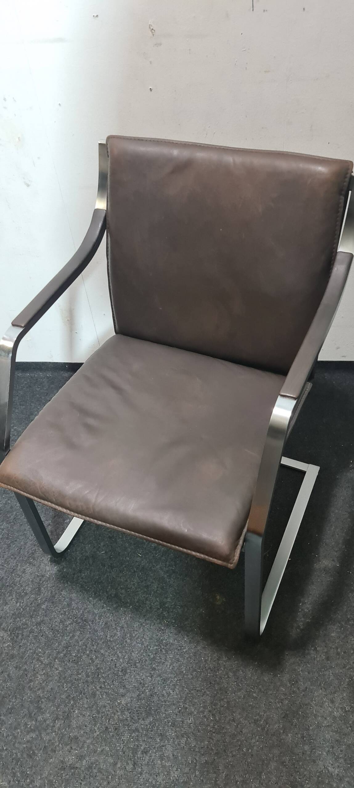 One of two vintage Leather and metal arm chairs.