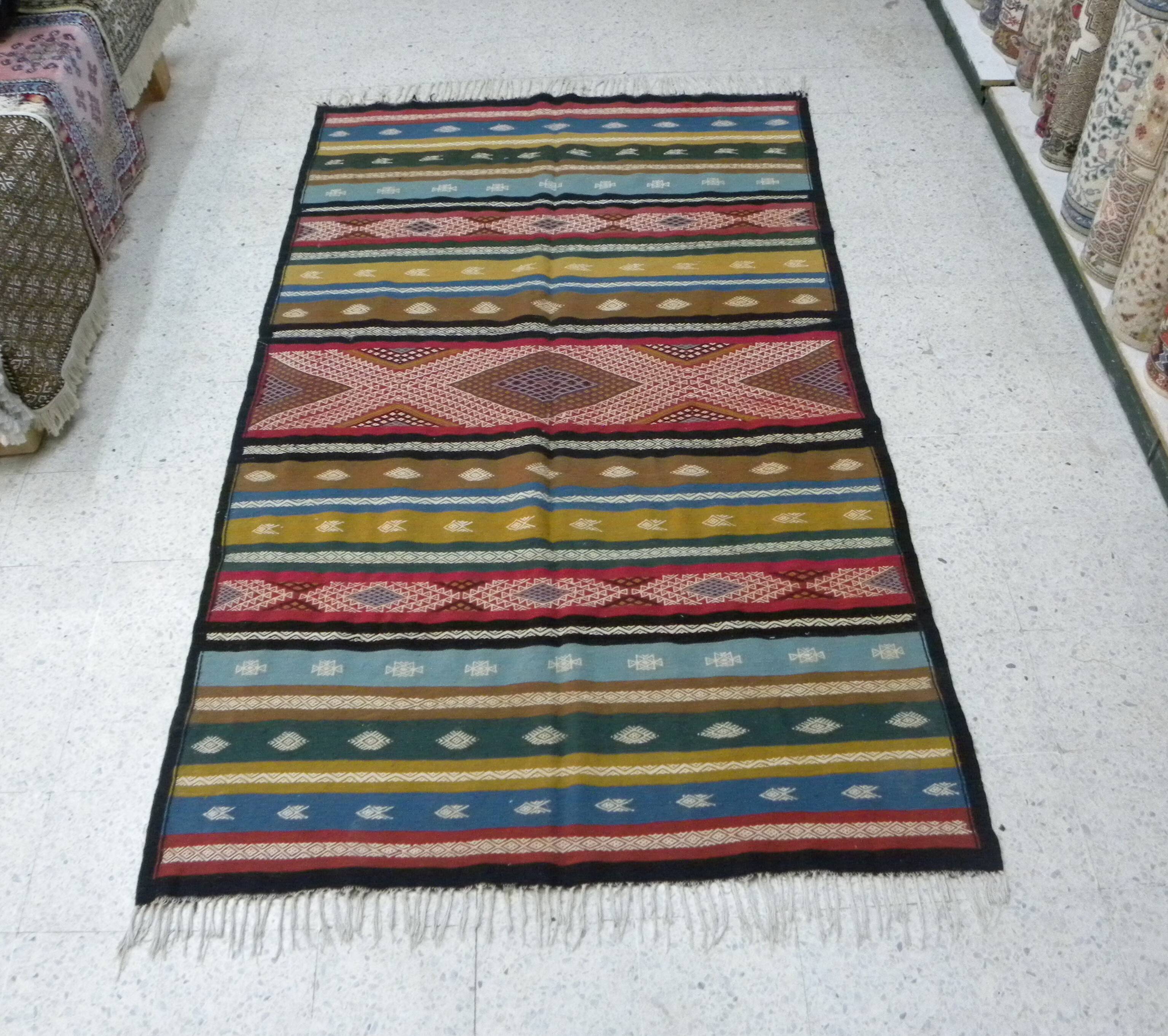 Traditional Berber tribal kilim rug with multicoloured geometric patterns.
