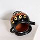 Old vase in glossy black ceramic, vintage exterior decoration.