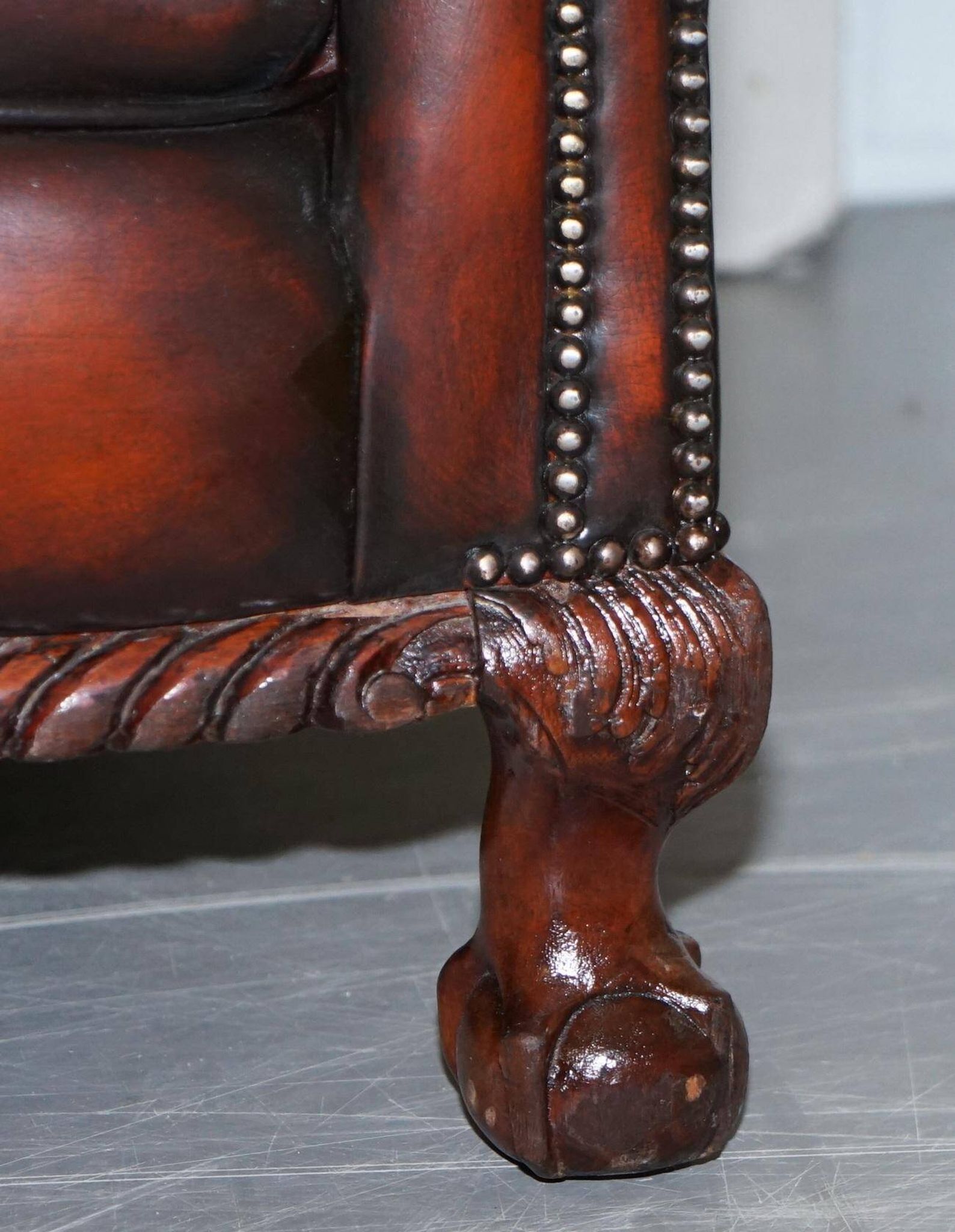 Restored Victorian sofa in leather with claw feet and feather cushions.