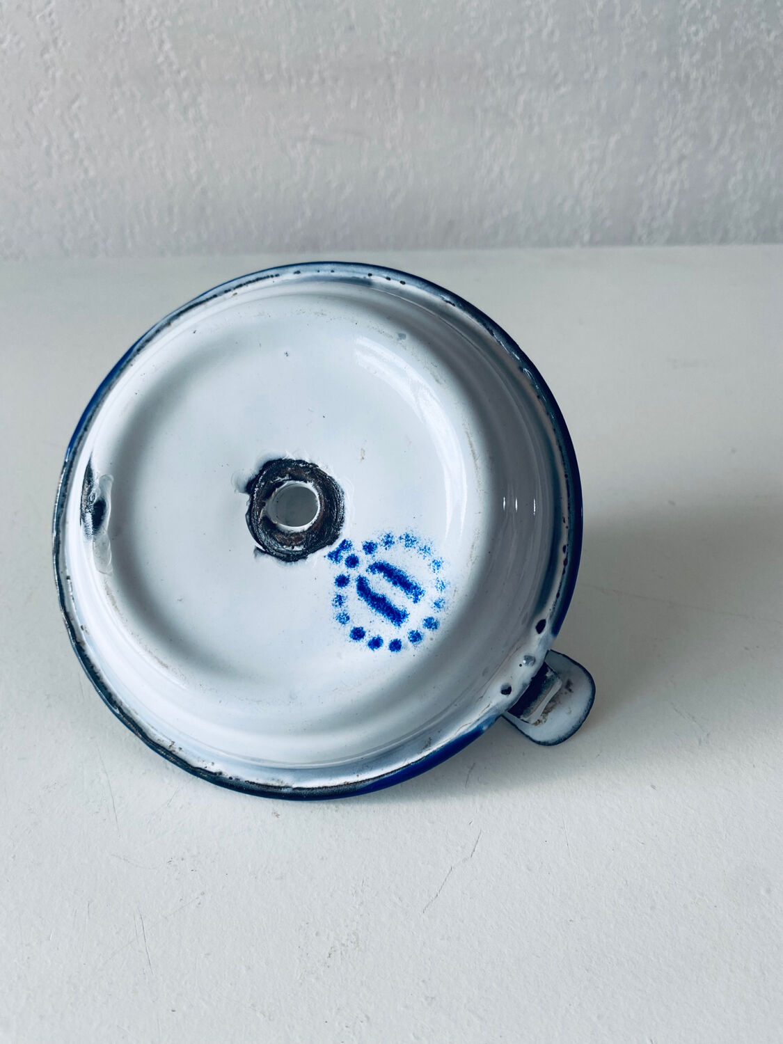 Old candle holder in white enameled metal