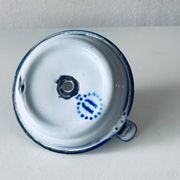 Old candle holder in white enameled metal