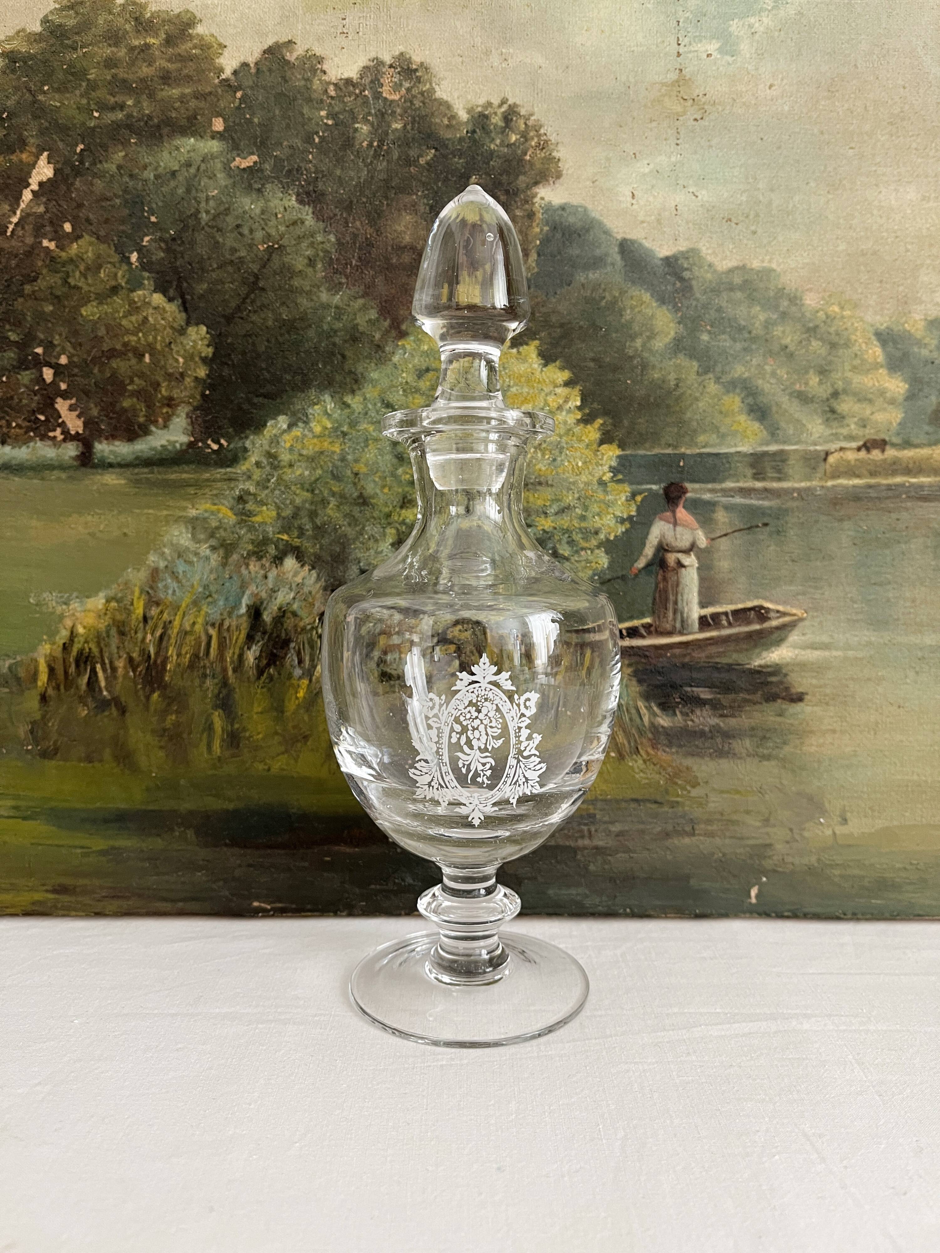 Antique stemmed blown glass bottle with engraved medallion