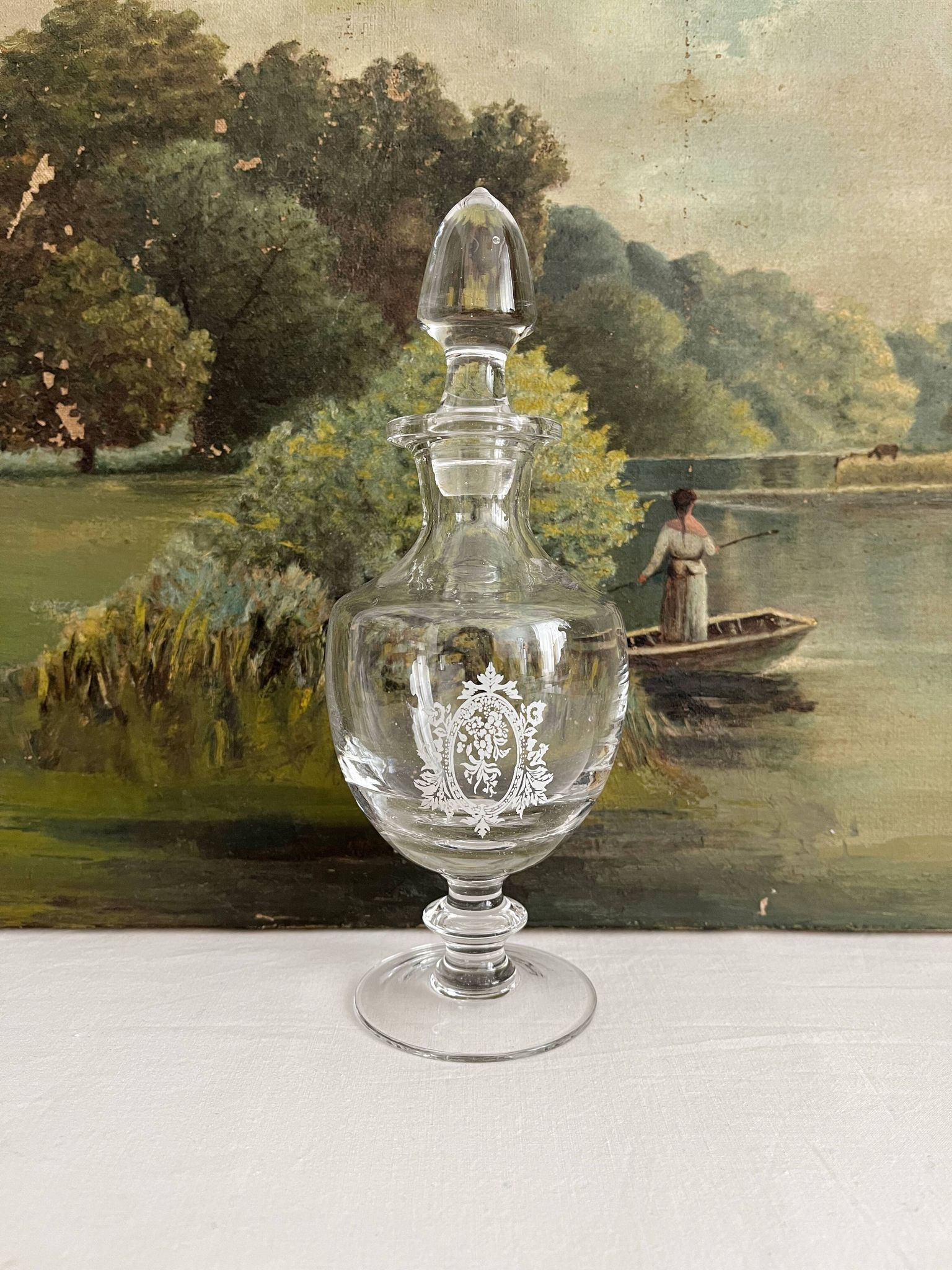 Antique stemmed blown glass bottle with engraved medallion