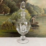 Antique stemmed blown glass bottle with engraved medallion