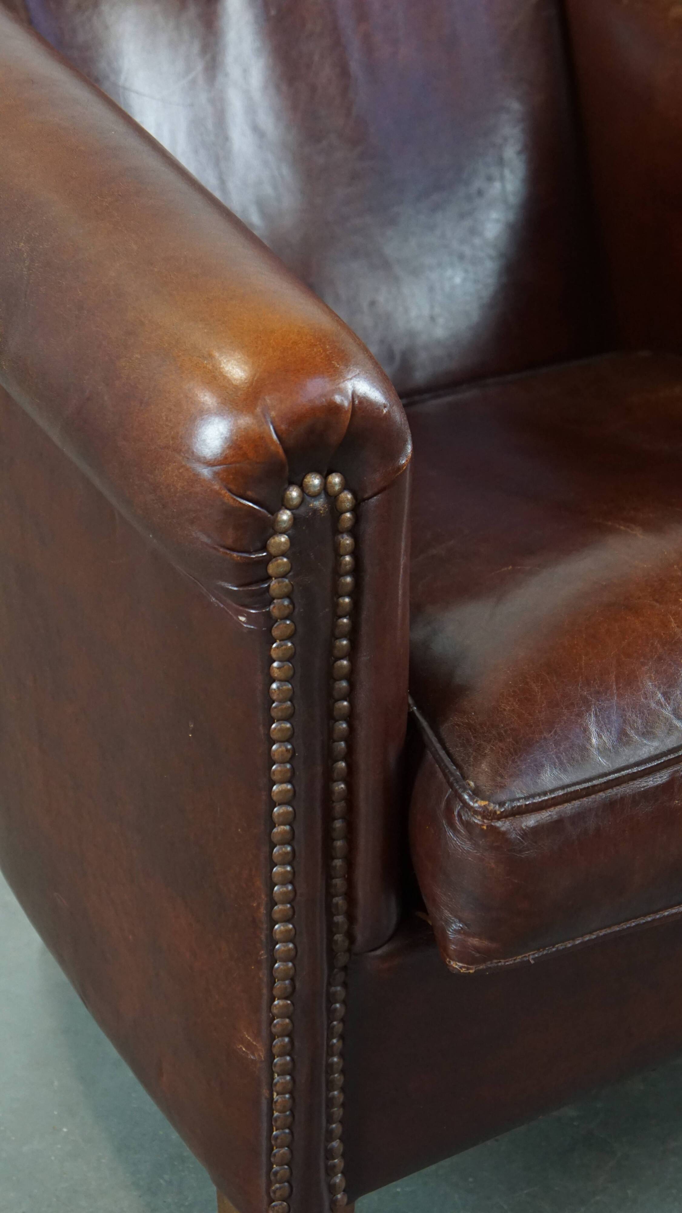 Sheepskin club armchair, correct finishing with decorative nails