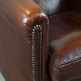 Sheepskin club armchair, correct finishing with decorative nails