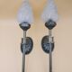 Pair of brass torch wall lights with globe flame.