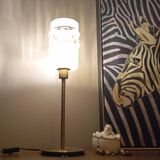 Table lamp with gold metal base and cylindrical textured glass shade