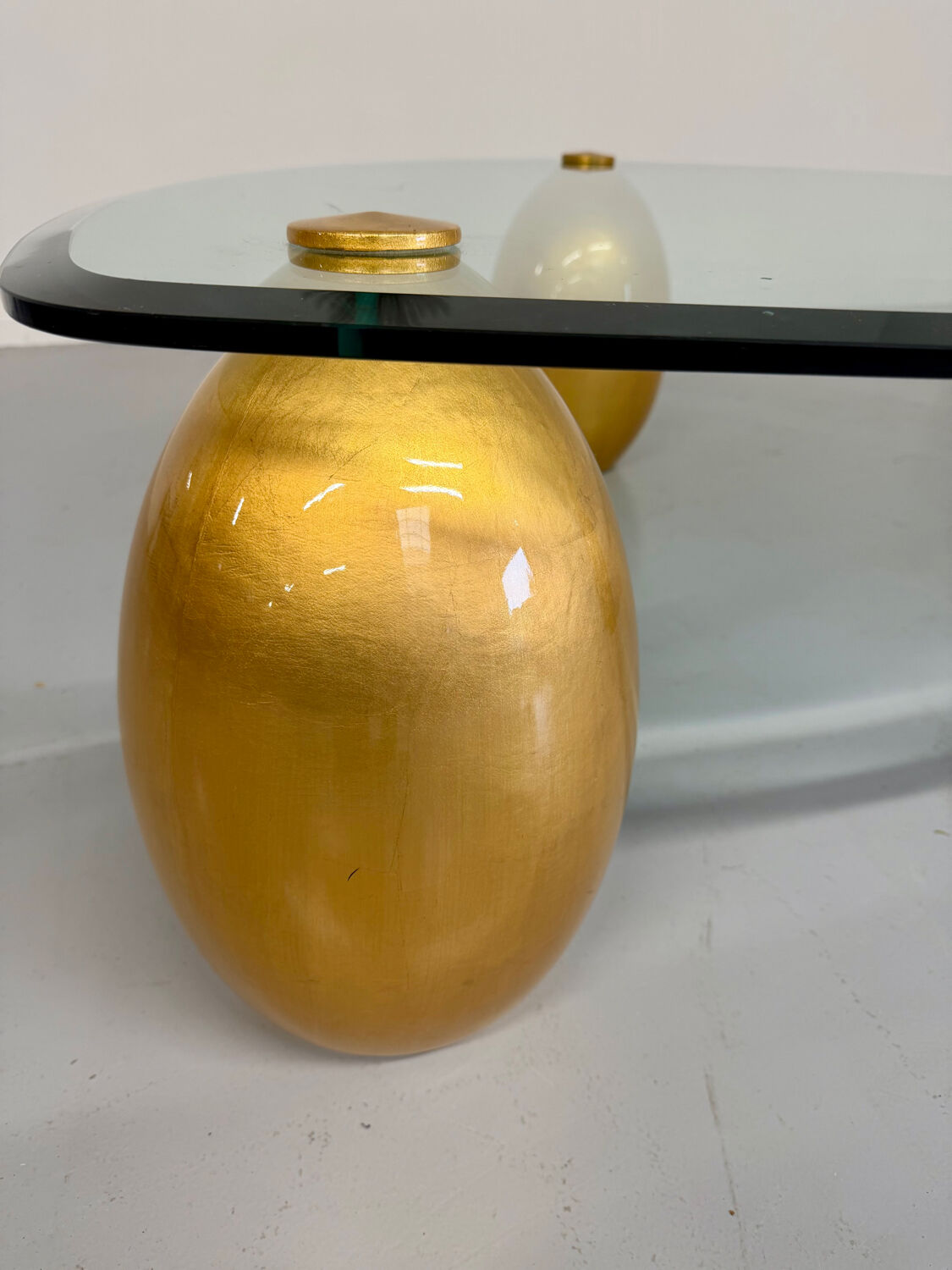 Vintage Italian design coffee table with a glass top and gold base, dating from the 1980s.