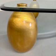 Vintage Italian design coffee table with a glass top and gold base, dating from the 1980s.