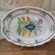 Old oval dish with floral motif called black bottom with staples