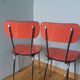 Chairs in red-orange formica and chrome metal.