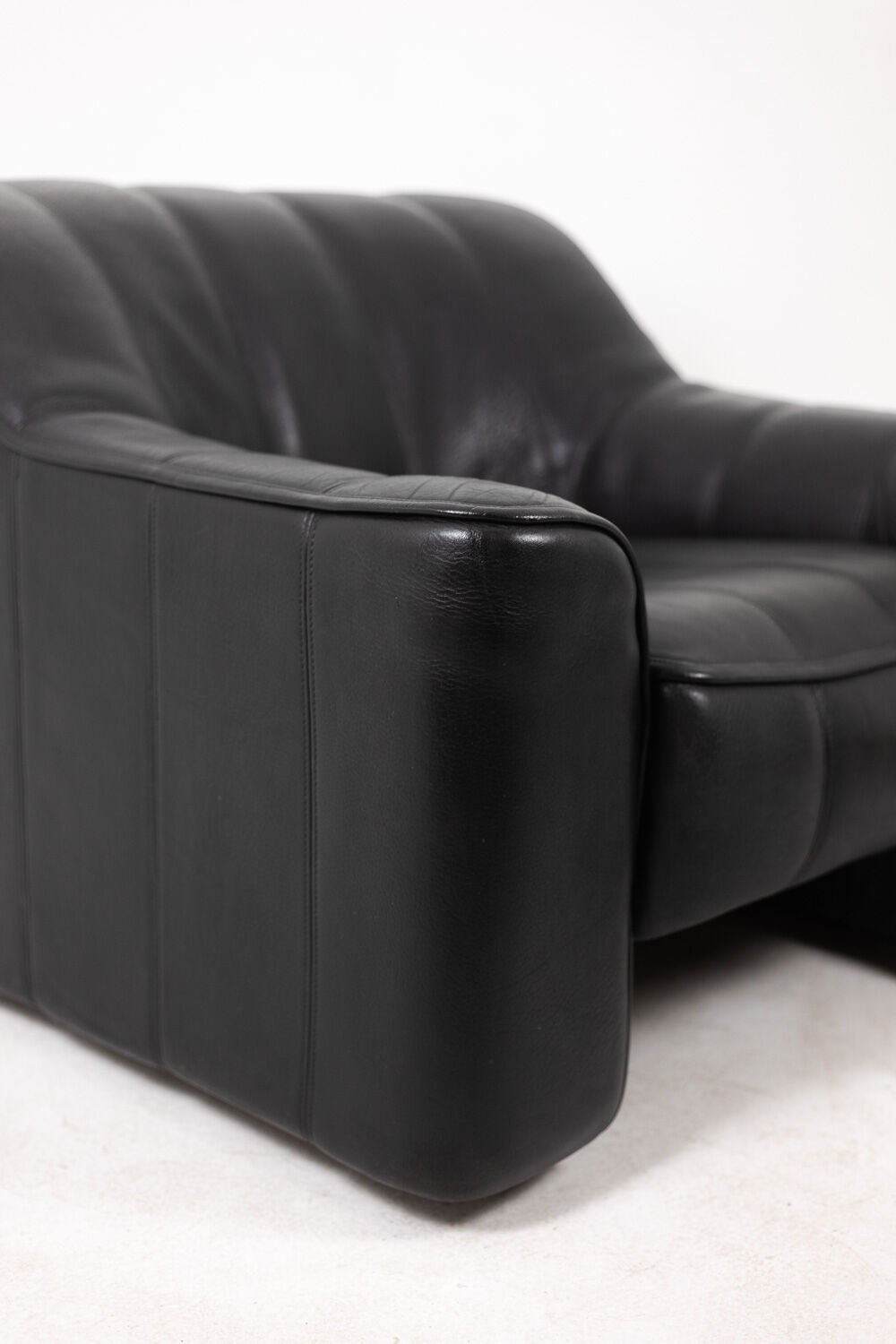 Maison De Sede. Armchair and its ottoman in black leather. 1970s.