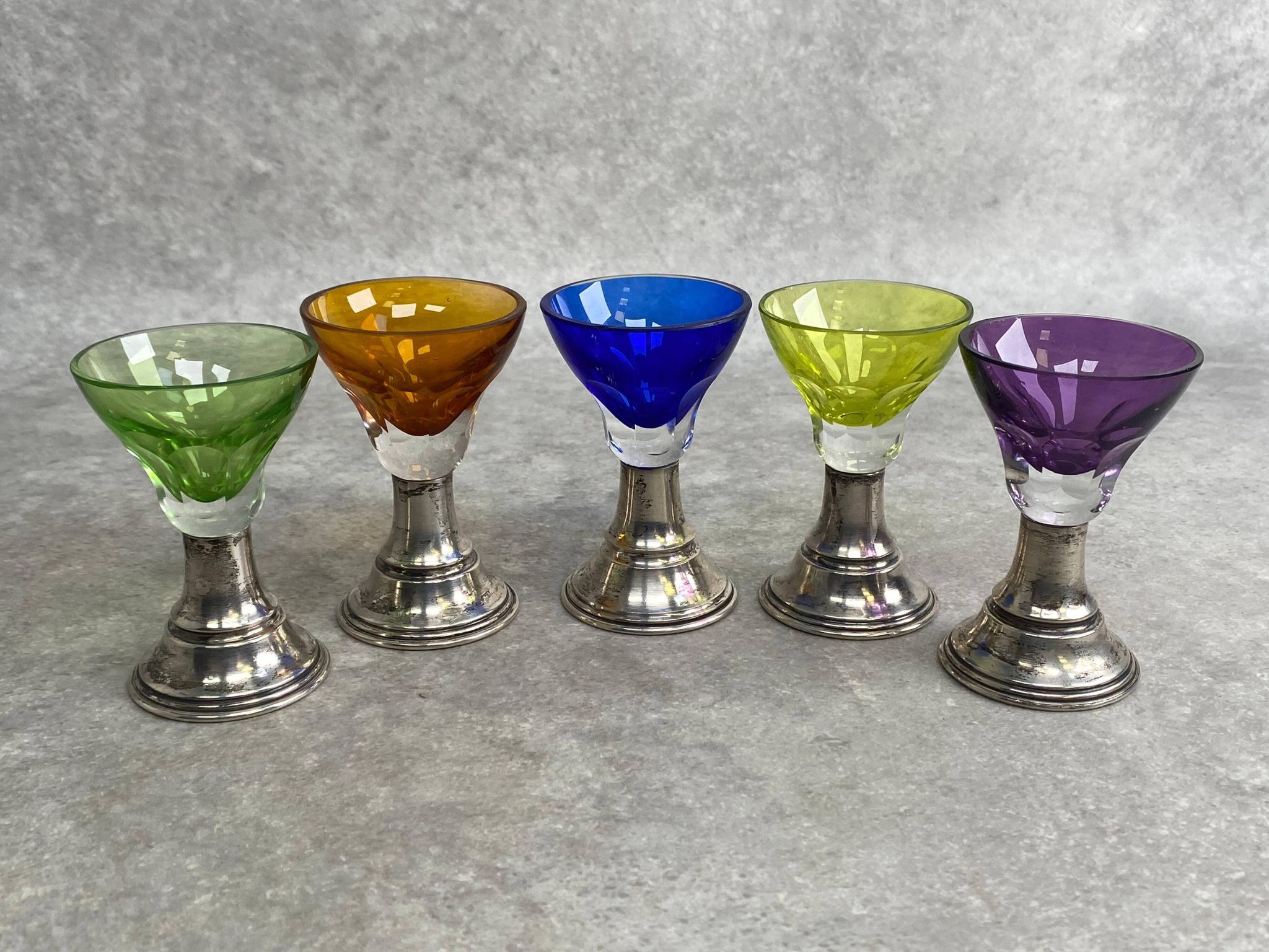 Set of 5 coloured stemmed glasses on silver stems.