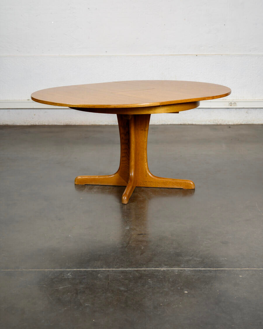 Round teak table with an extension.