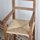Vintage wooden high chair for children with a straw seat.