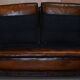 Two-seater canapé in aged leather, Victorian style.