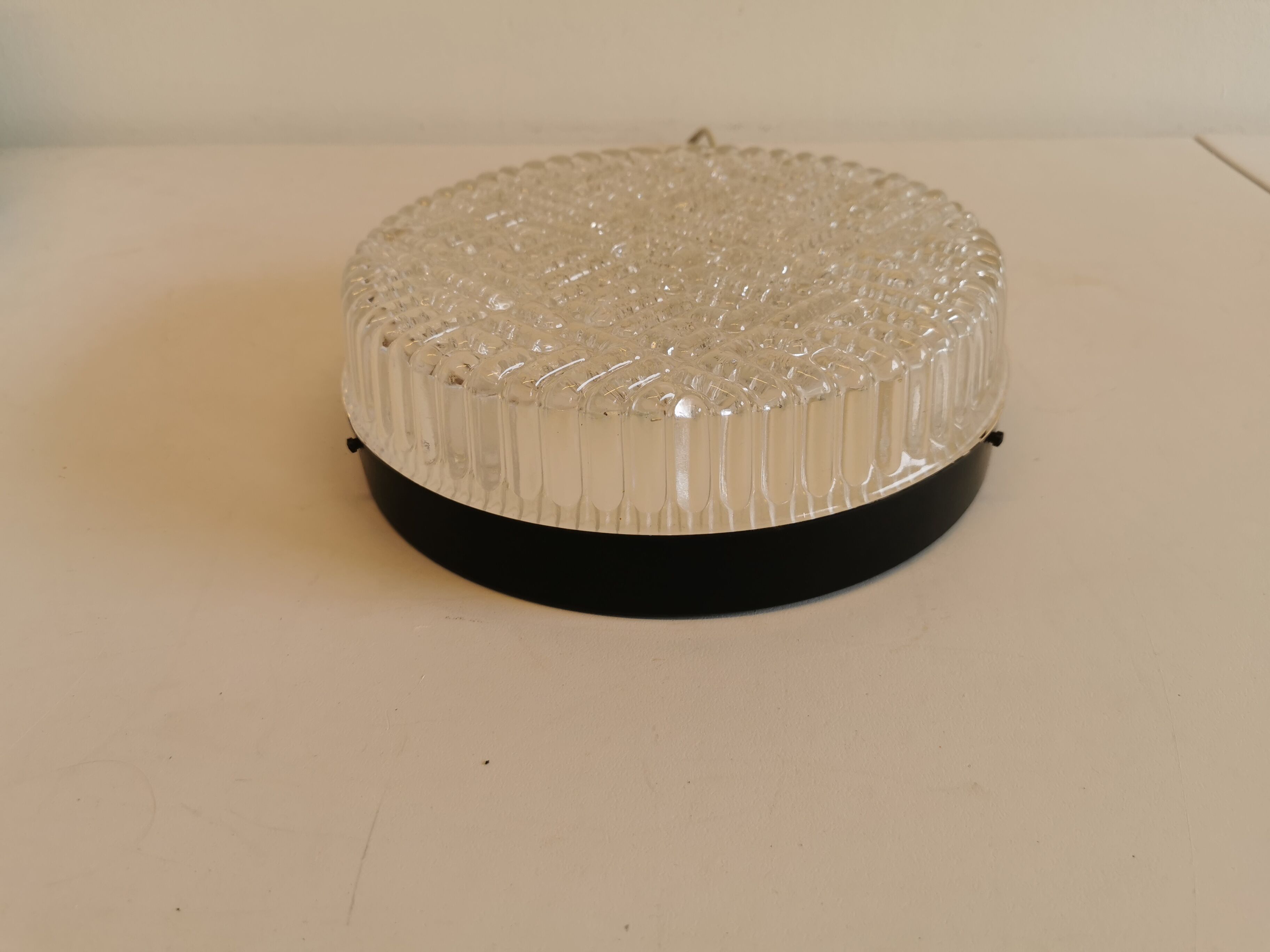 Ceiling light, in dark metallic paint with thick glass shade with beautiful details in the glass.