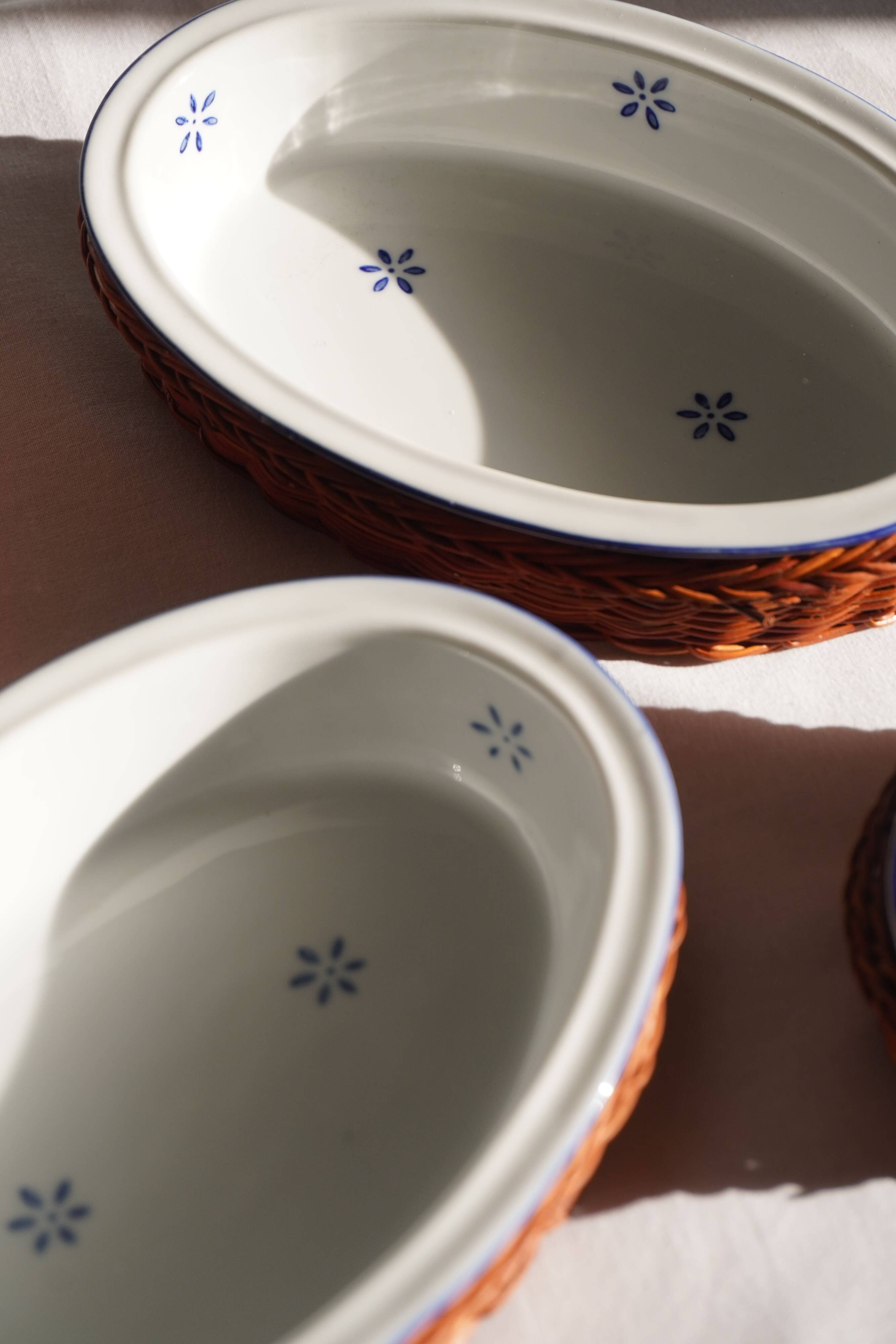 Set of 4 white porcelain dishes with blue decorations and wicker stands