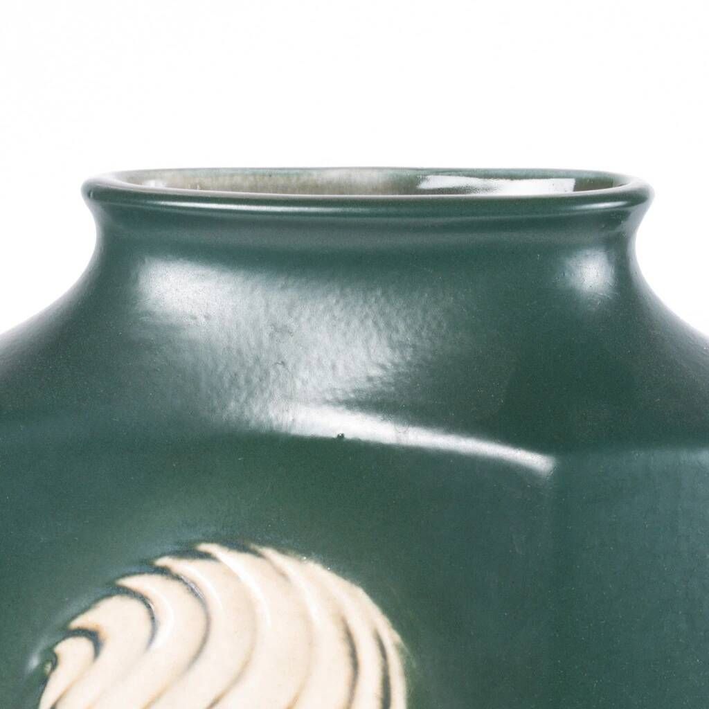 A tall ceramic vase glazed with dark green colour