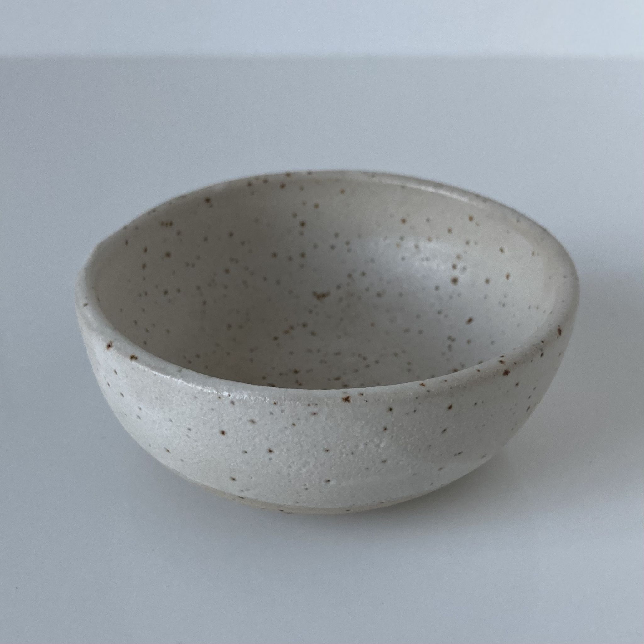 Meeting of three artist's ceramic objects including two pots and a cream covered bowl