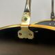 Neoclassical log holder in brass and black lacquered brass