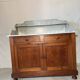 Antique wood and marble kitchen sideboard with carved backsplash