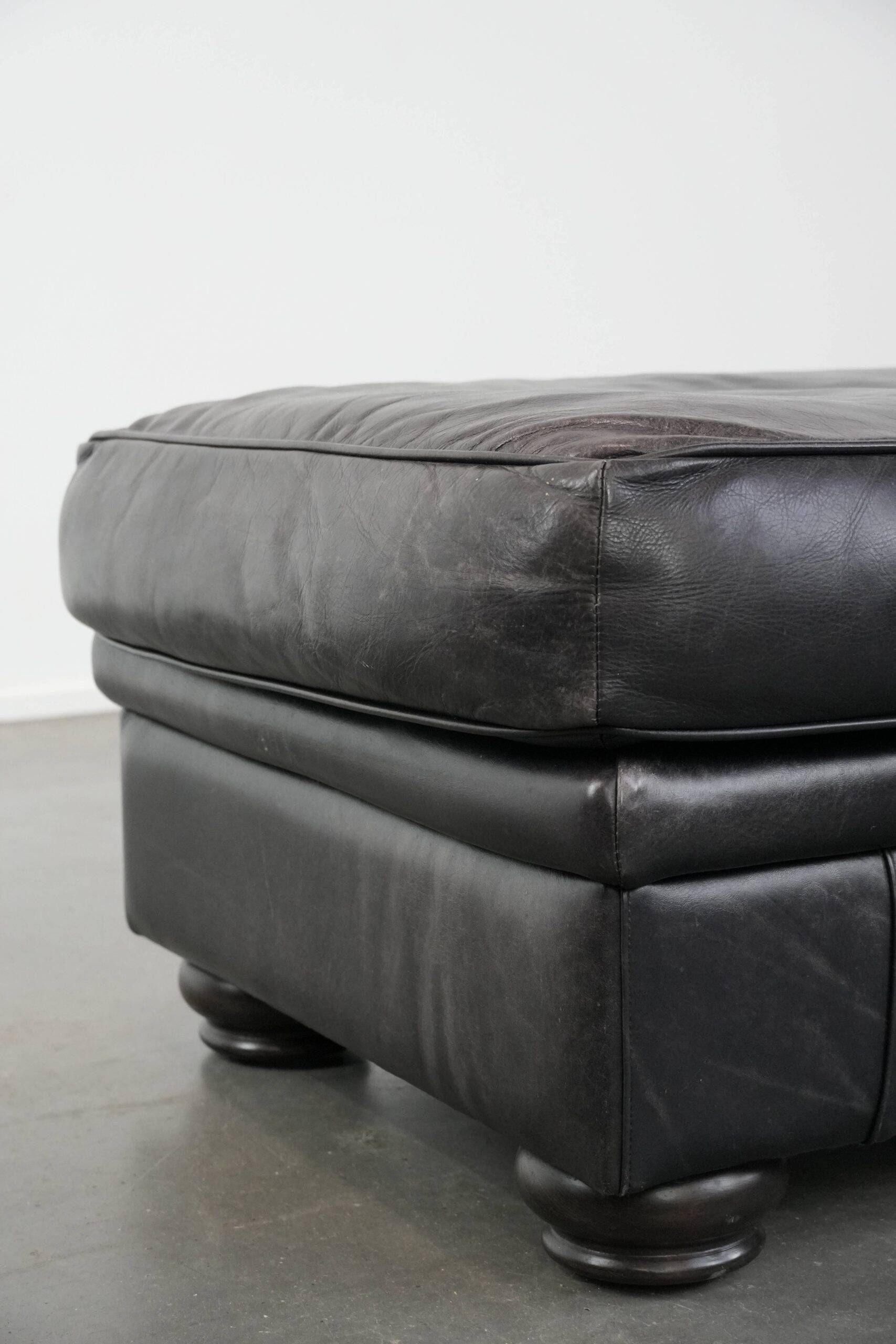 Large and timeless black ottoman made of cowhide leather in English style