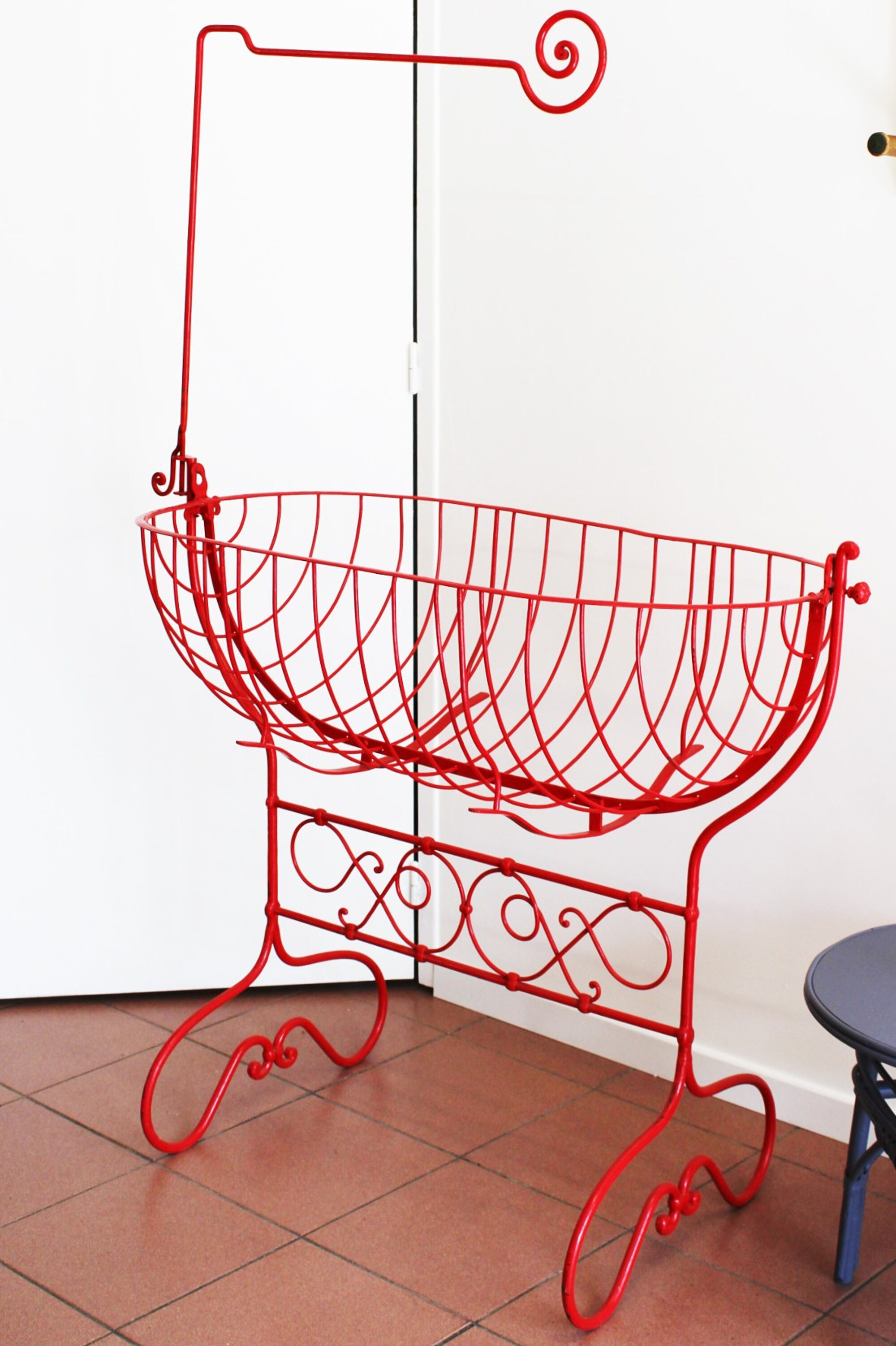 Baby cradle in red wrought iron