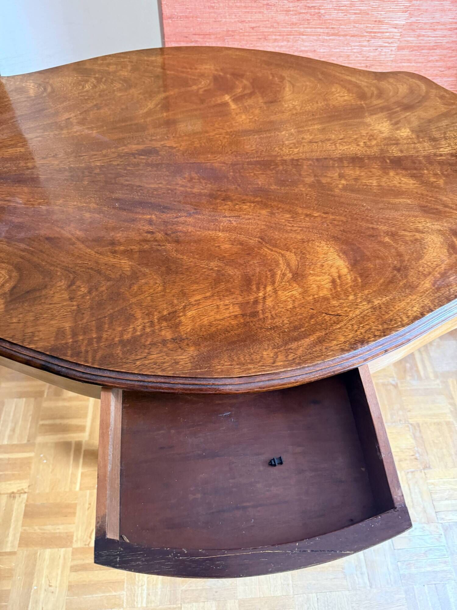 Antique mahogany table with a scalloped top and a sculpted central leg.