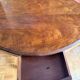 Antique mahogany table with a scalloped top and a sculpted central leg.