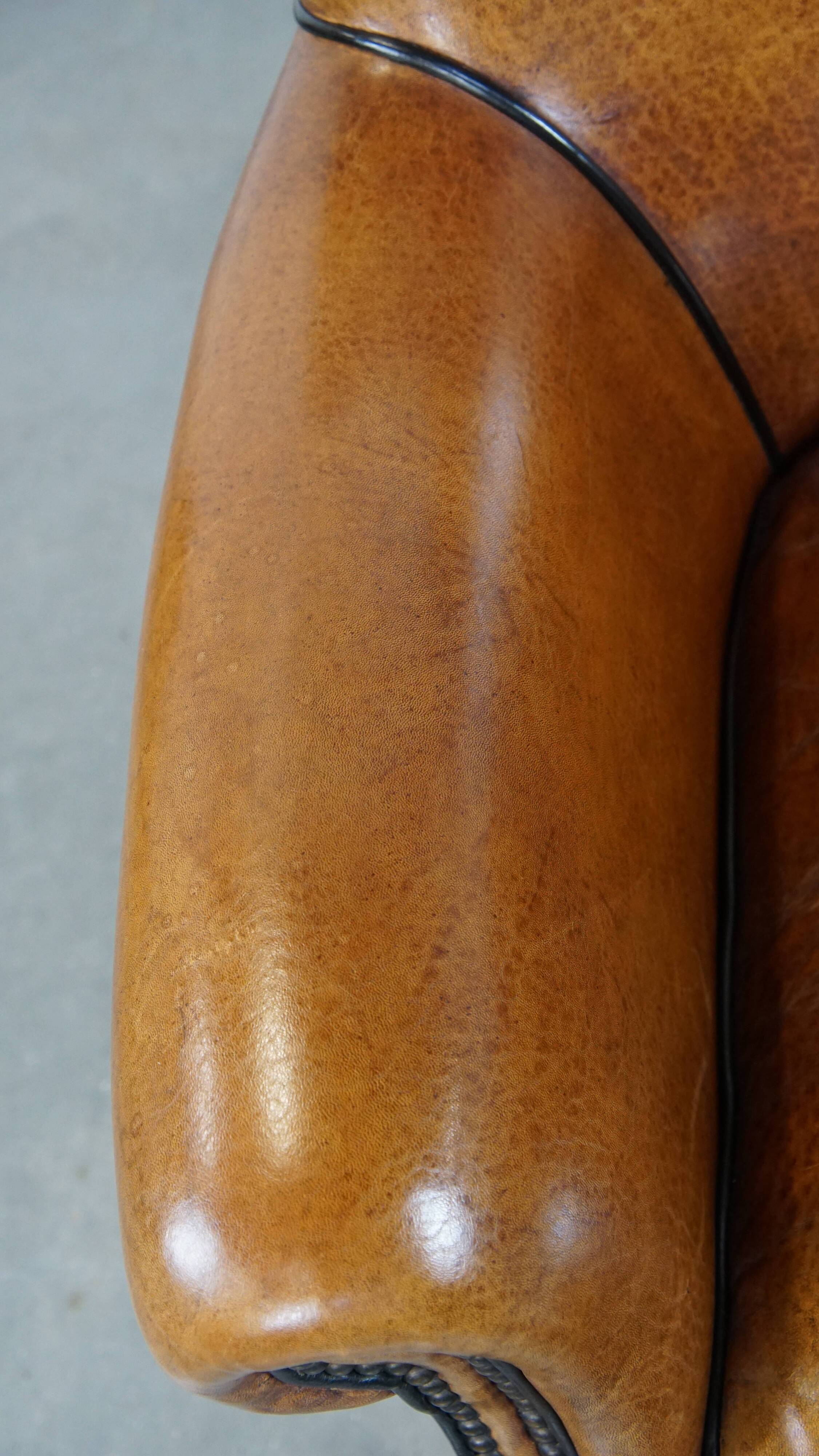 Cognac-colored sheep leather armchair finished with decorative nails