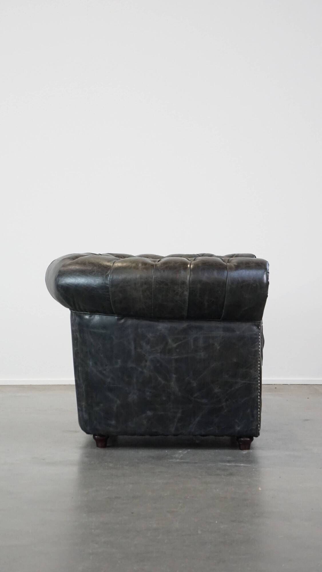 Spacious black cow leather chesterfield armchair with distinctive character