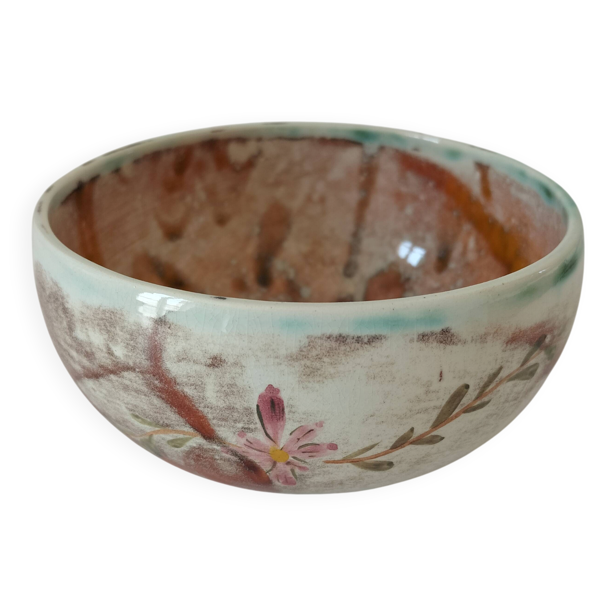 Red-orange glazed ceramic workshop bowl with floral decoration.