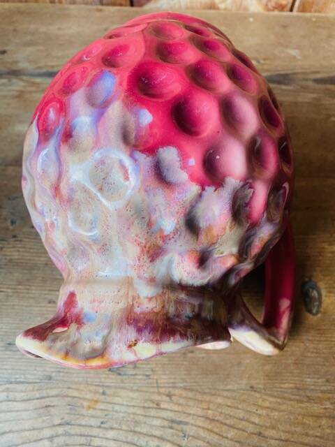 Old pitcher in burgundy ceramic