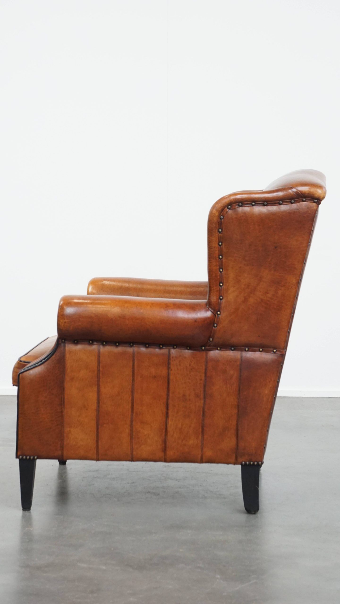 Sheepskin wingback armchair with stitching and black piping