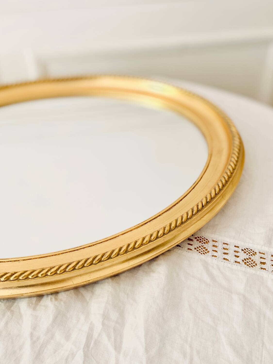 Oval wall mirror in gilded wood