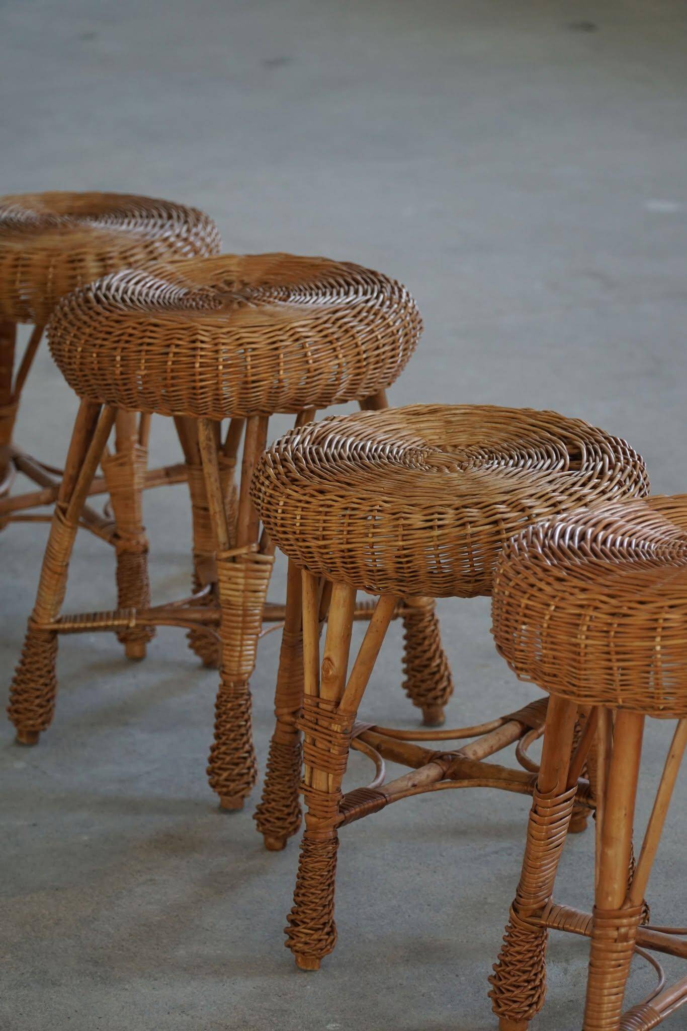 A set of 4 vintage Scandinavian rattan stools, in the style of Tony Paul, from the 1960s.
