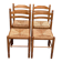 4 solid wood kitchen chairs with straw seats in a country farmhouse style.