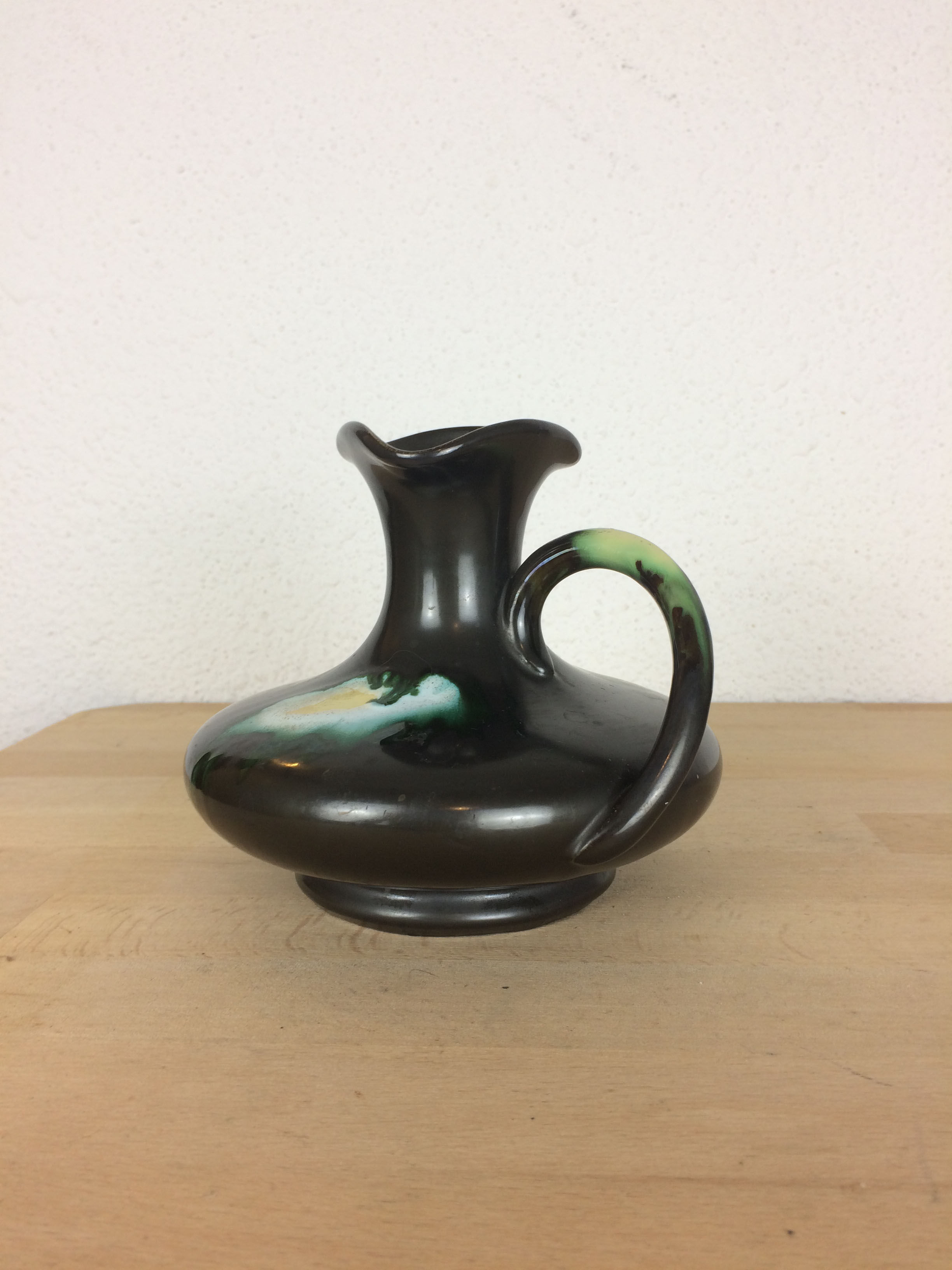 Thulin Belgium pitcher, black ceramic handle