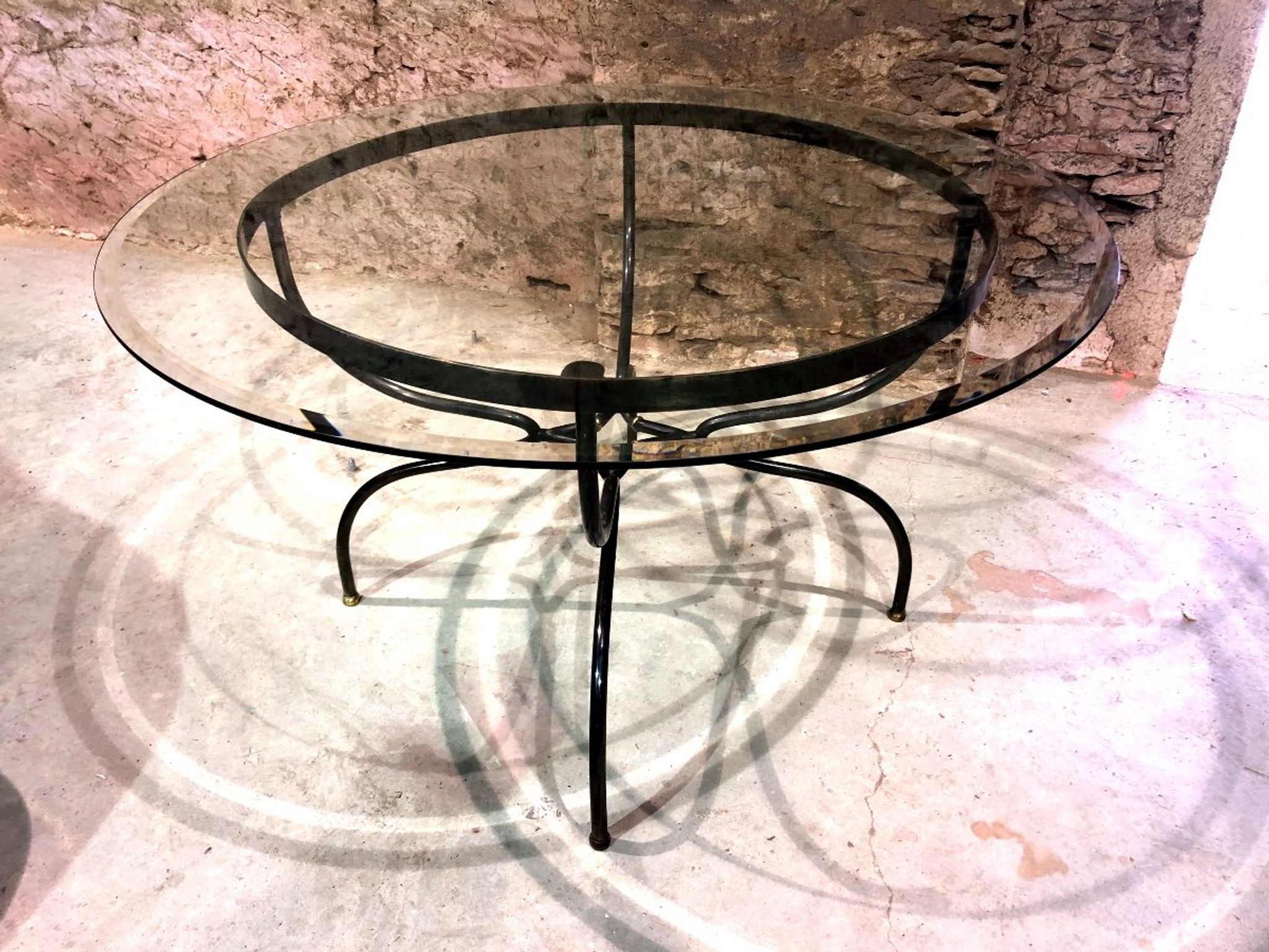 Table de salle à manger piètement fer forgé et laiton, plateau de verre., années 1980