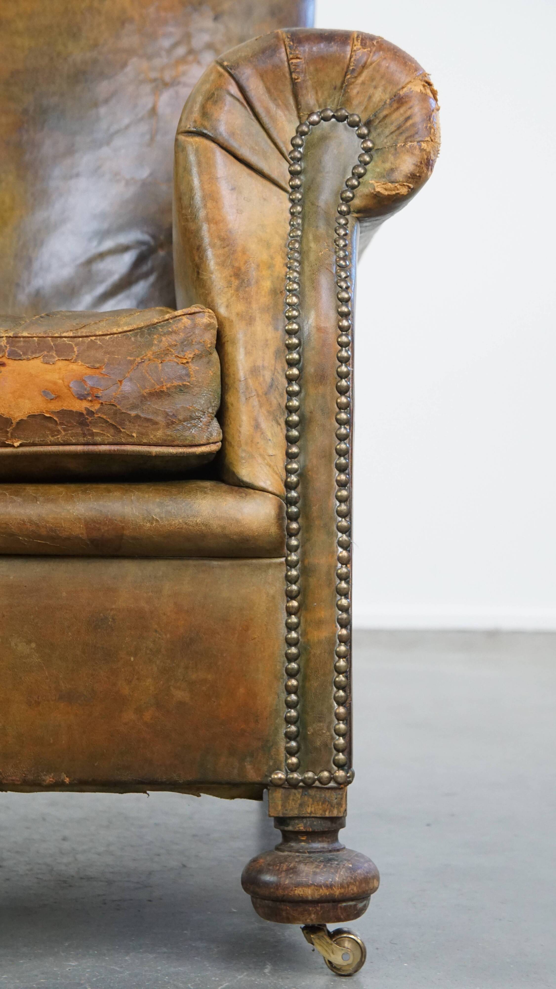 Green antique English cowhide leather armchair on wheels
